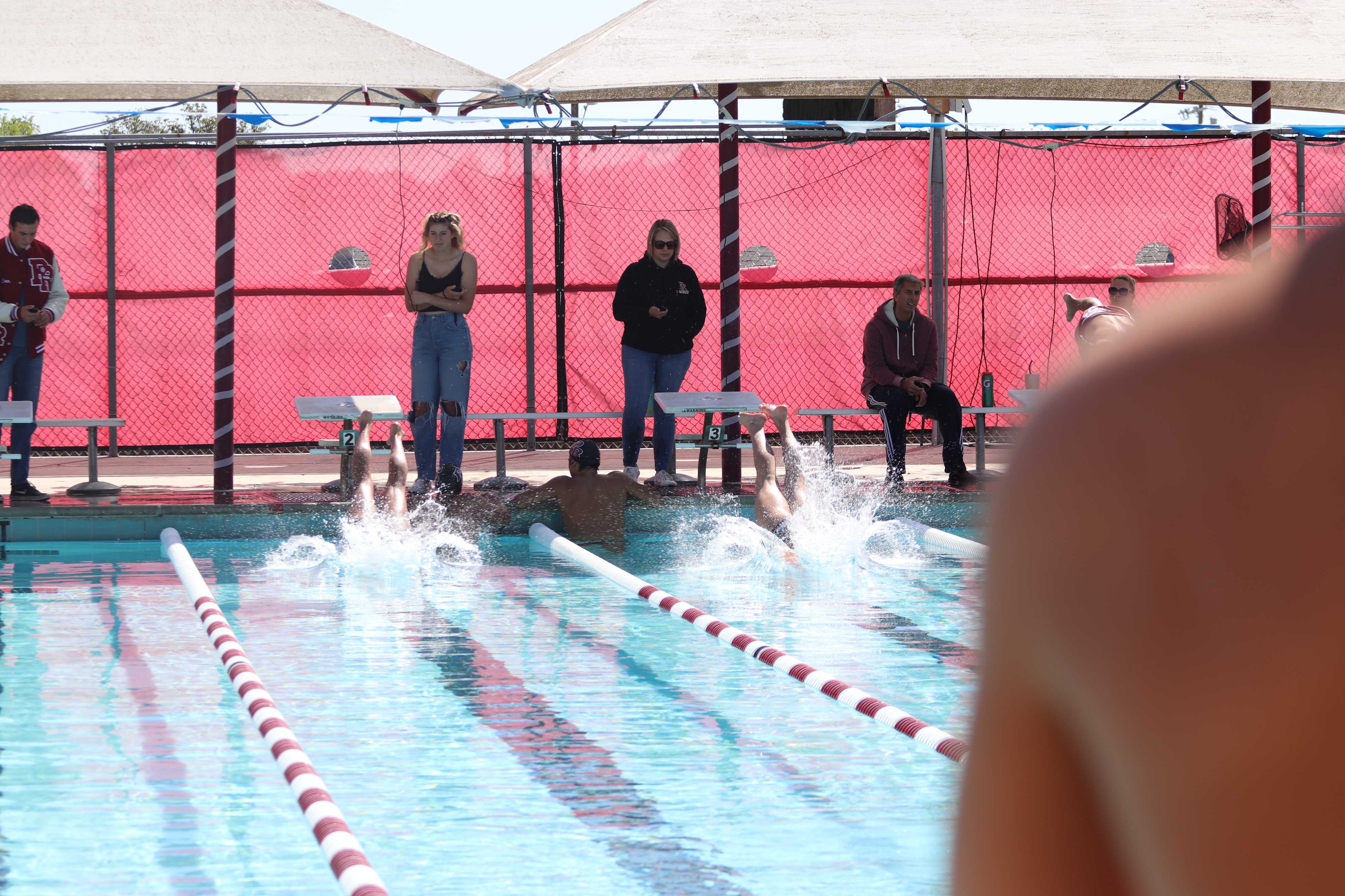 Senior Co-Captains Jackson Parr (left) and Reily Lowry (right) dive into the pool for the 100 Free Race.