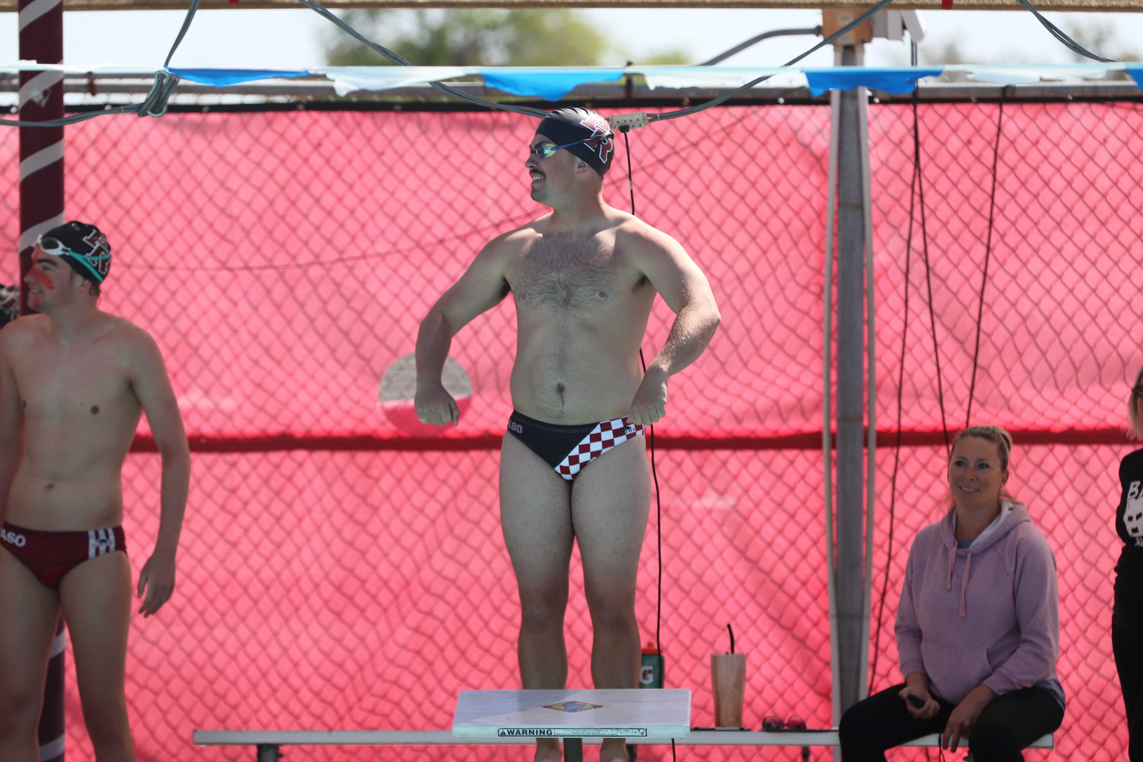 Varsity Mens Coach shows off his muscles before the coach vs. senior relay