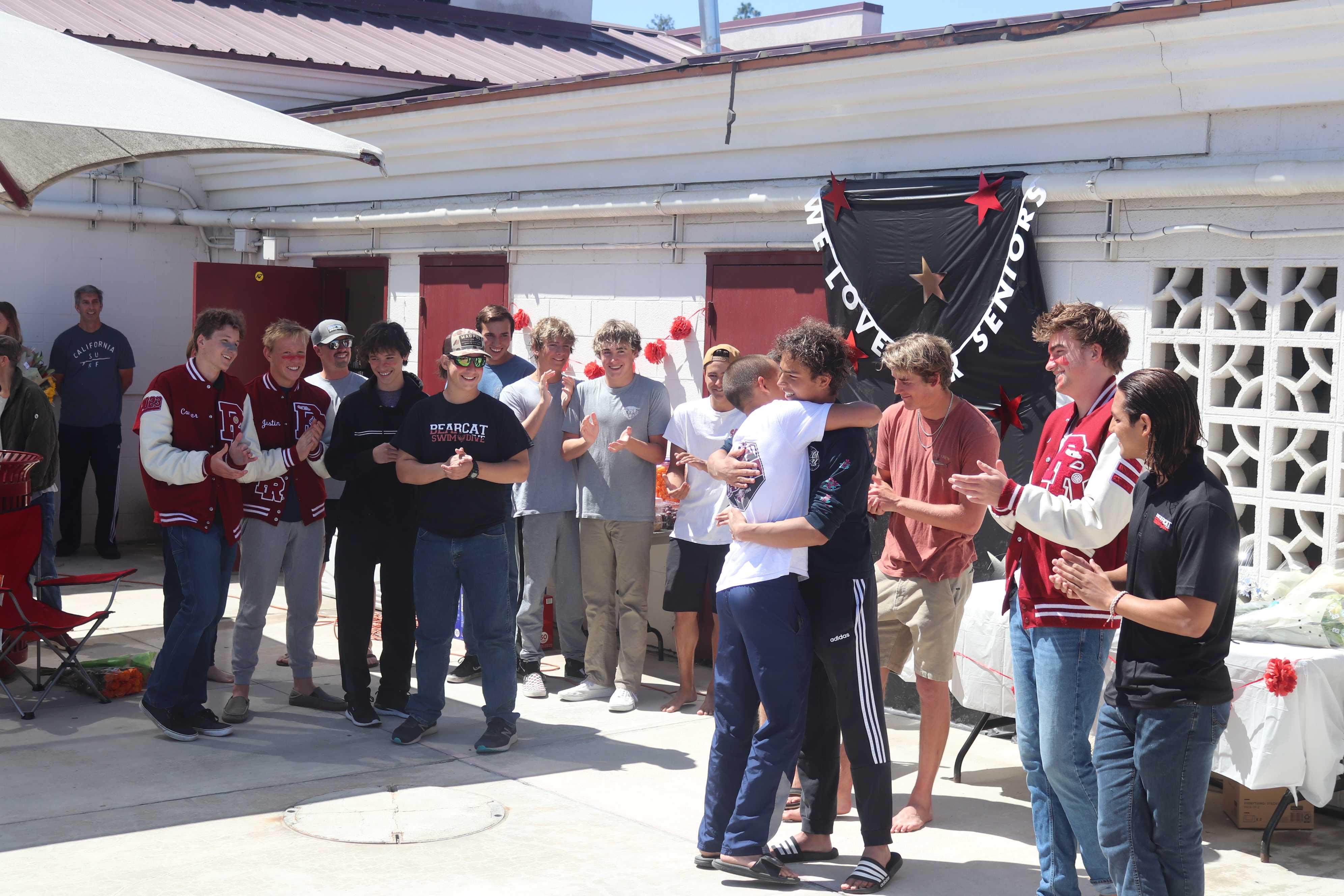 Senior ceremony is shown as freshmen and senior embrace in an emotional goodbye.